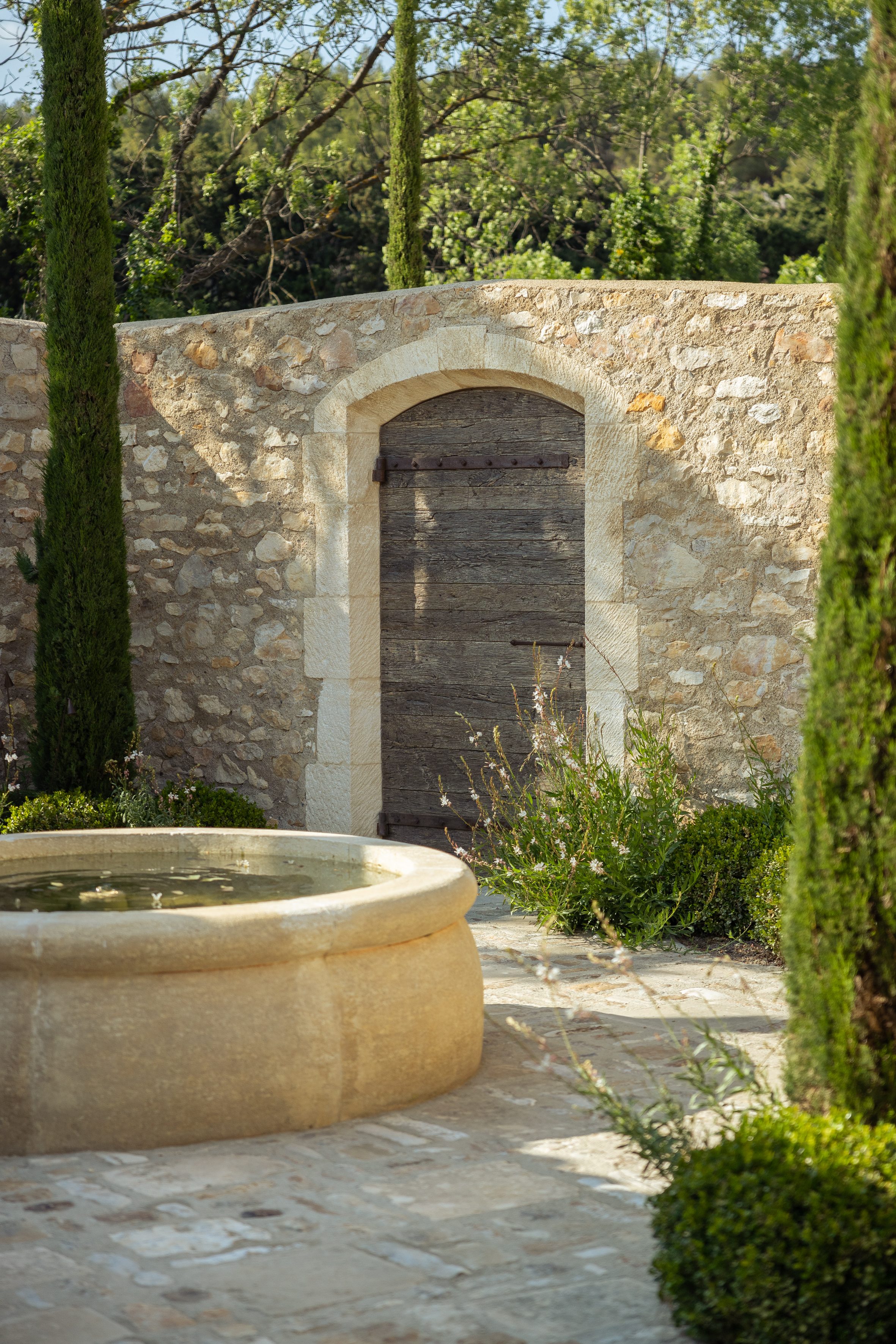 Bassin circulaire et cyprès verticaux
